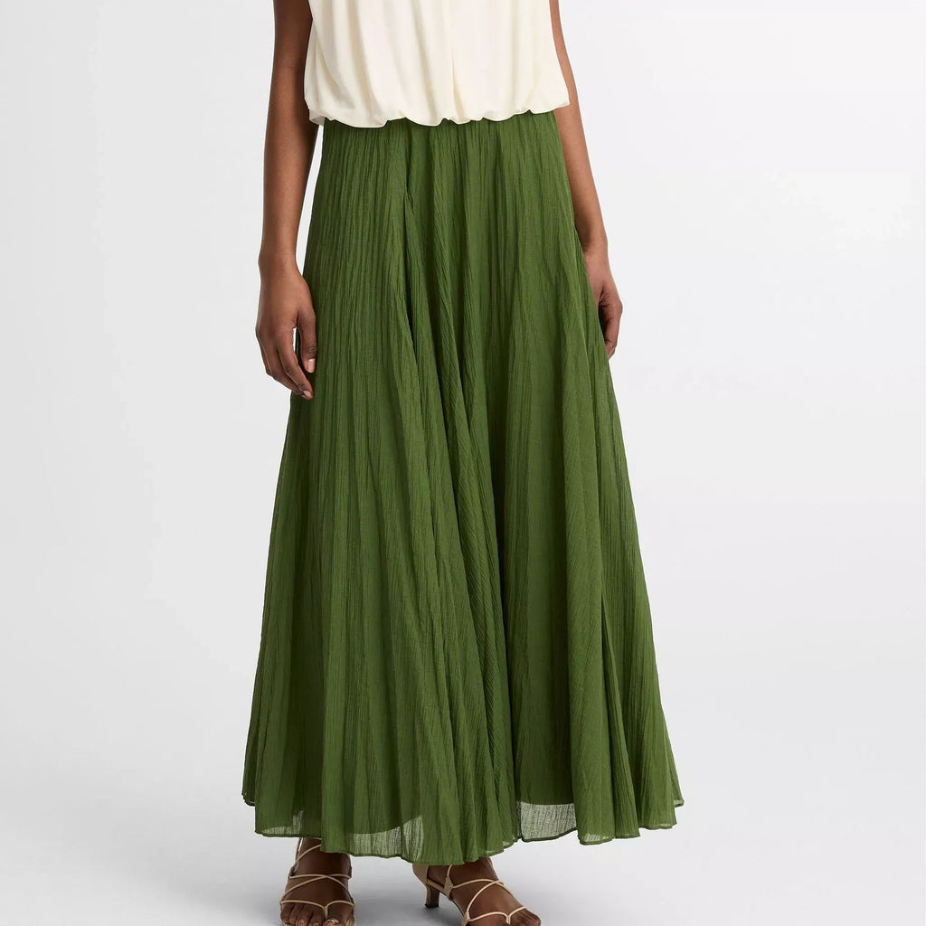 Person wearing a white top and green skirt on a white background