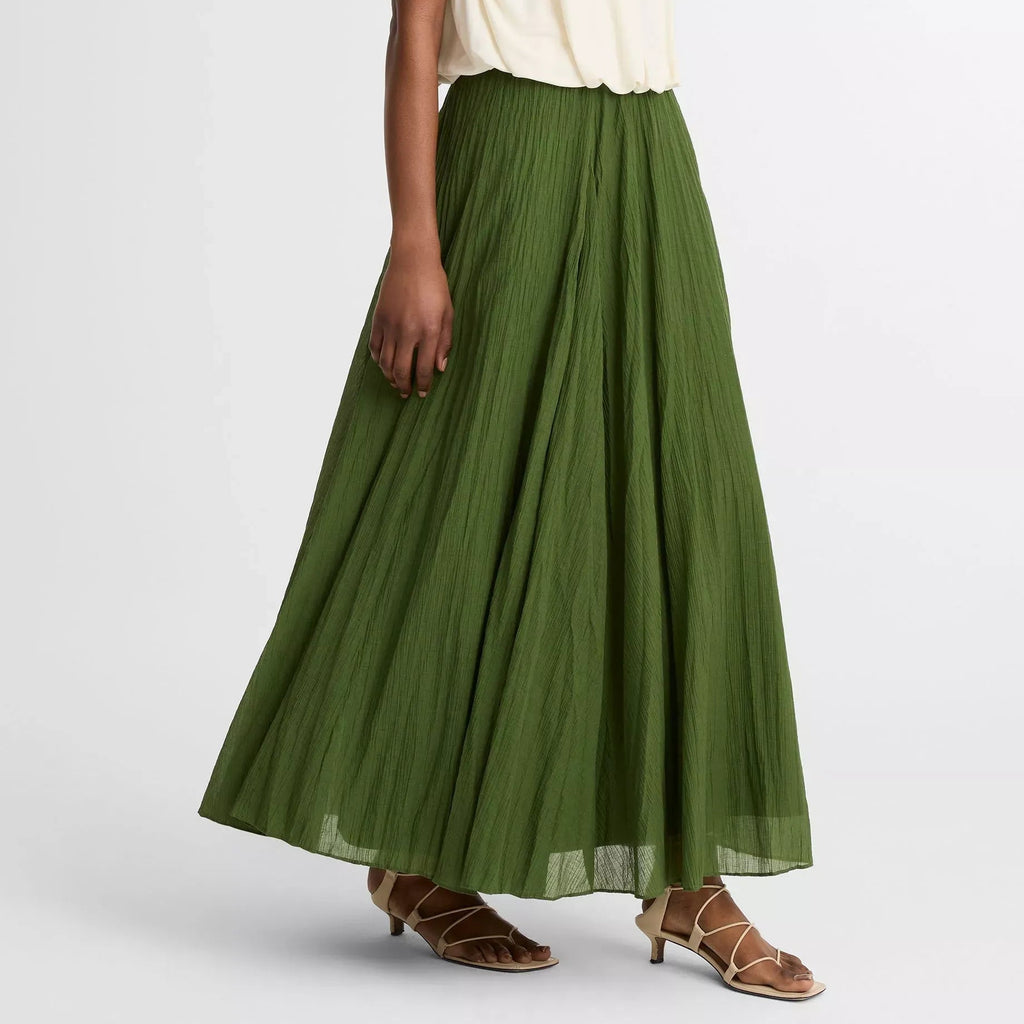 Woman wearing a white top and green skirt on a white background